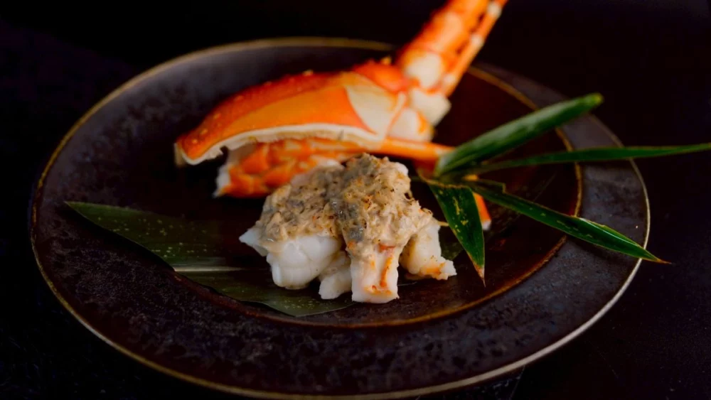 圖/莞固和食將伊勢海老與松葉蟹佐以特製美乃滋進行焗烤,鮮甜多汁的蟹肉與蝦肉完美融合,鹹甜交織的奶香口感濃郁綿密,讓人吮指回味。(莞固和食 提供)